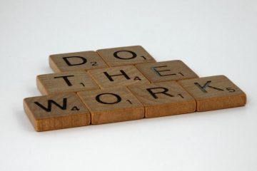 Motivational message spelled out with scrabble tiles on white background.